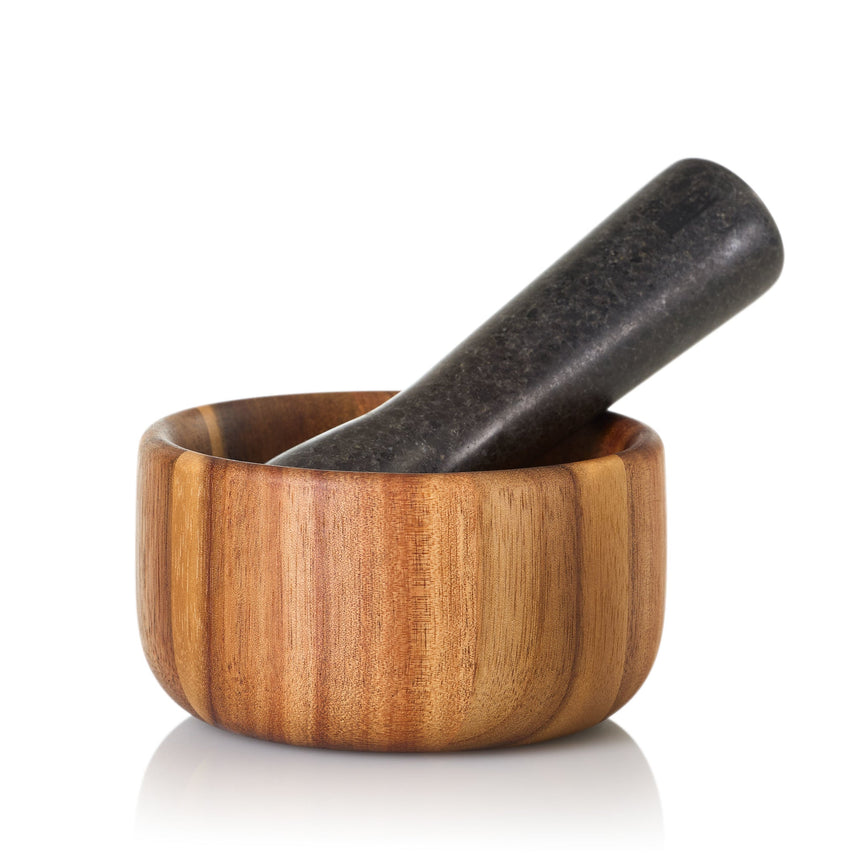 Wooden mortar and pestle with a dark stone pestle.