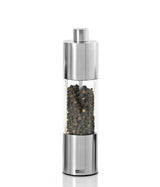 Stainless steel and glass pepper mill or grinder filled with peppercorns.