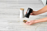 Salt and pepper shaker set with one white and one black container.
