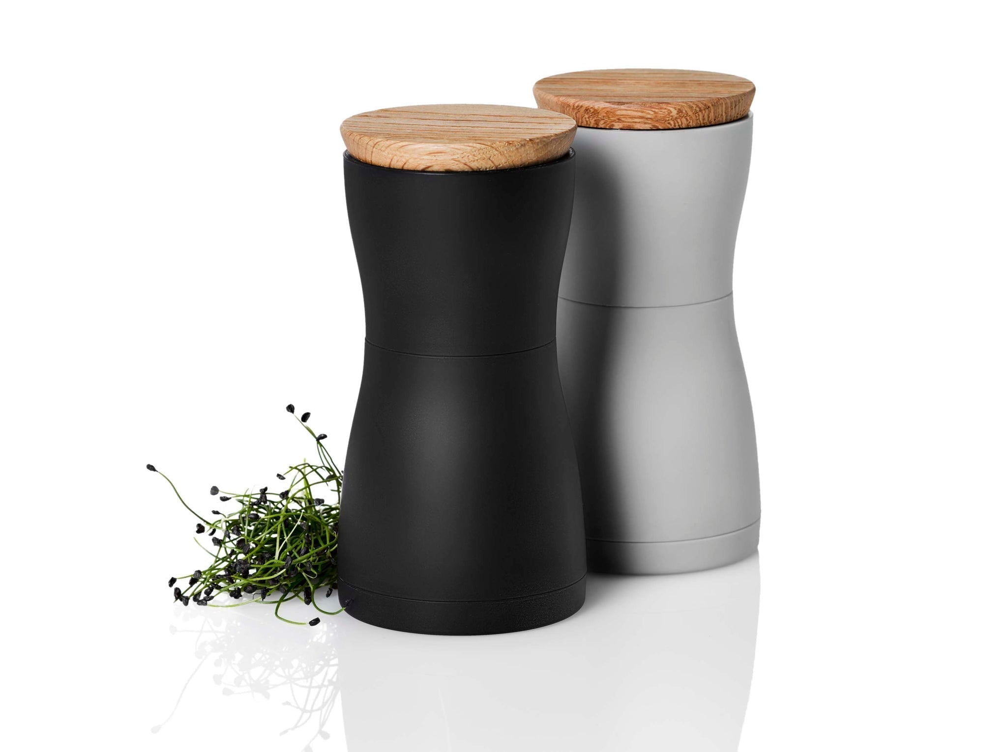 Pair of modern salt and pepper shakers with wooden lids.