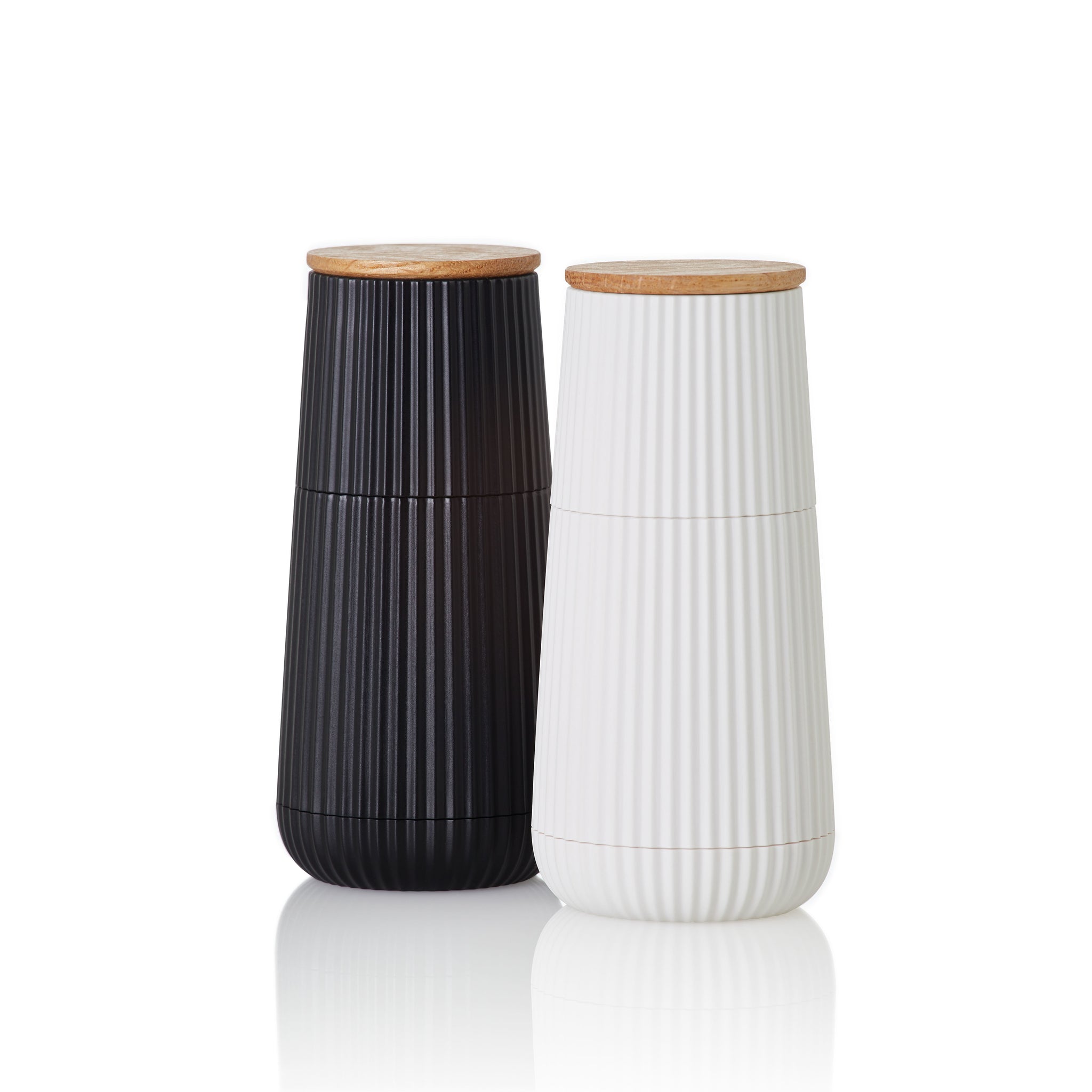 Two tall, cylindrical ceramic containers with wooden lids and vertical ribbed textures, one black and one white.