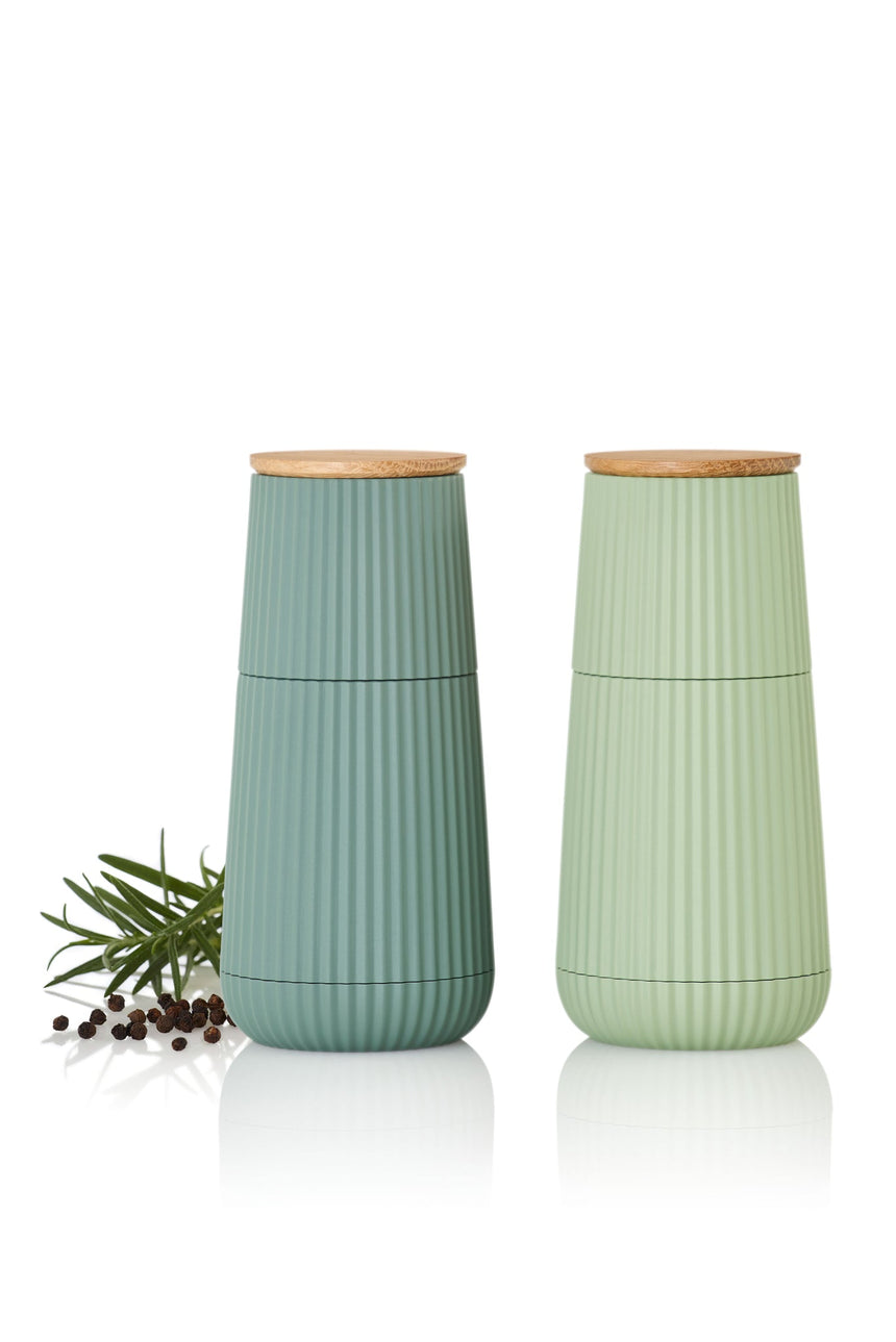 Two ribbed ceramic vases with wooden lids in muted green tones.
