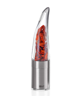 Sleek stainless steel and glass pepper mill or spice grinder with visible red chili peppers inside.