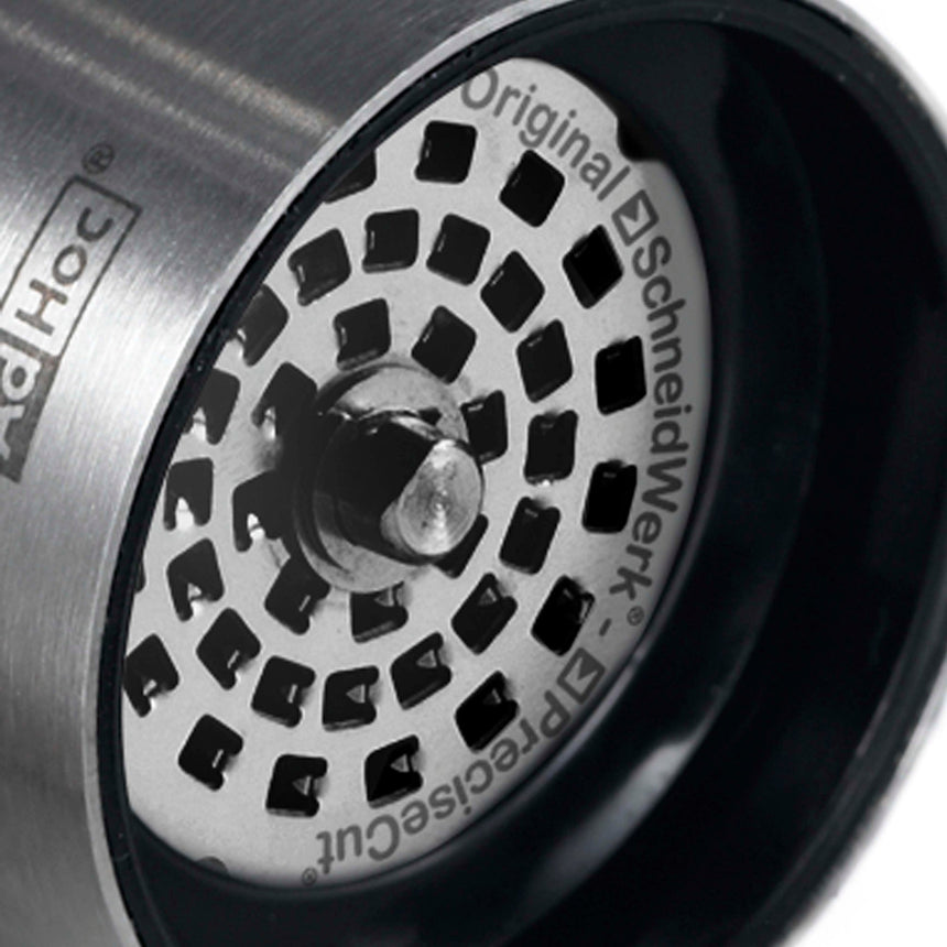 Circular speaker grille with a spiral pattern of square holes.