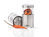 Stainless steel spice grinder with a clear container holding dried chili peppers.