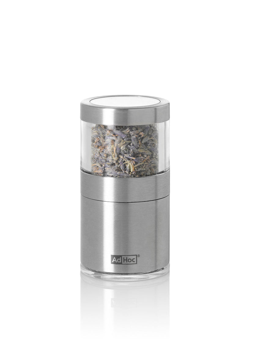 Stainless steel and glass salt or pepper grinder with visible spices inside.