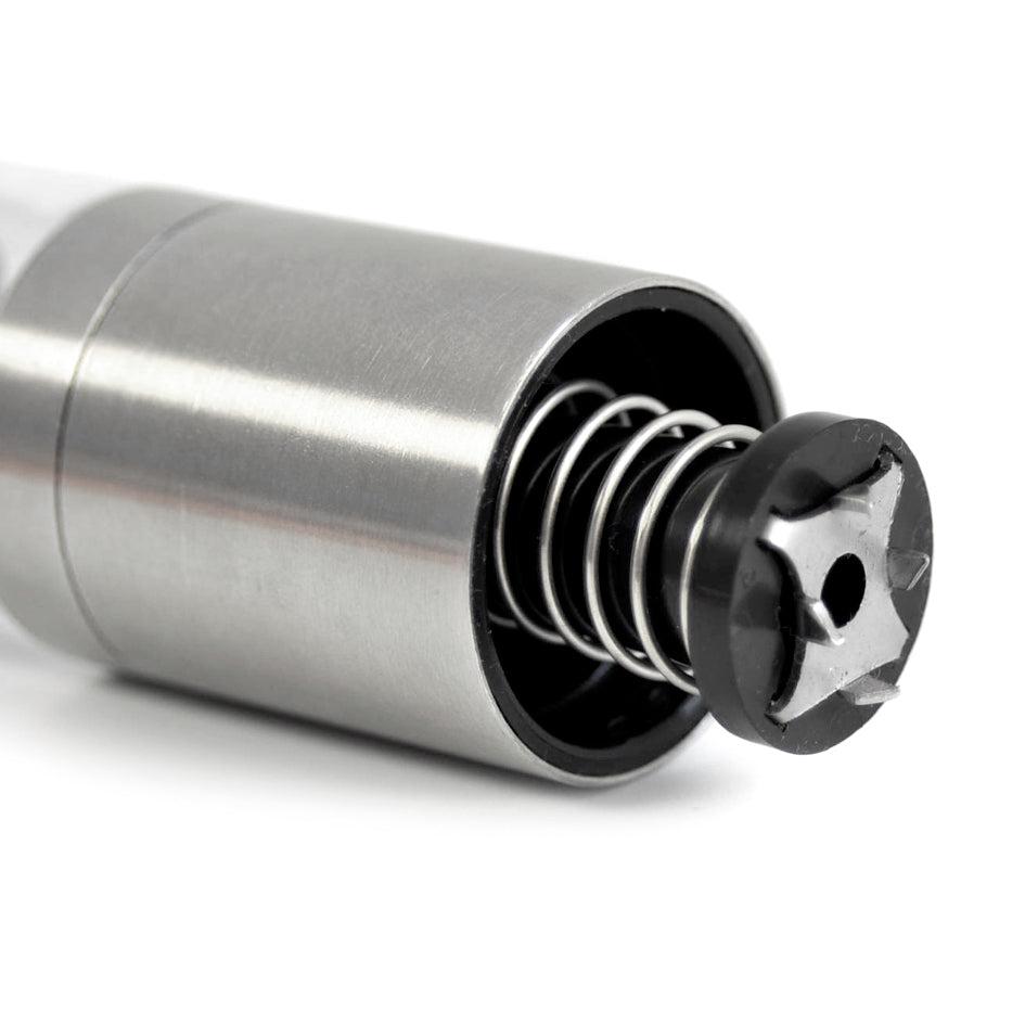 Stainless steel cylindrical device with an exposed internal spring mechanism.