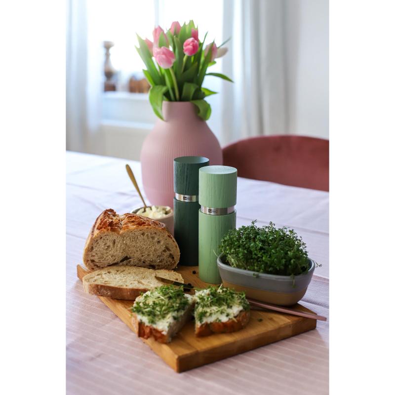 Sliced bread on a wooden cutting board with herb spread.