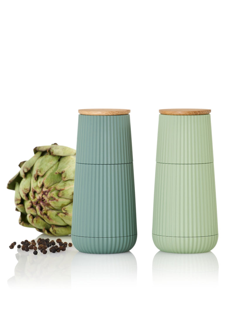 Two ribbed ceramic containers with wooden lids in pastel blue and green colors.