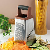 Four-sided stainless steel cheese grater with a brown handle on top.