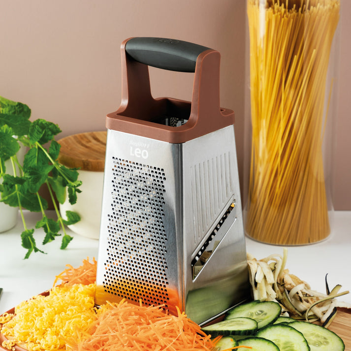Four-sided stainless steel cheese grater with a brown handle on top.