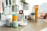 Collection of kitchen storage containers and utensils on a countertop.