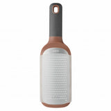 Bottle-shaped lint roller with a gray handle and copper-colored base.