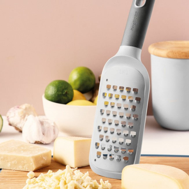 Cheese grater with a gray handle and white grating surface.