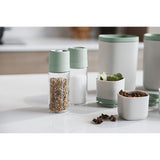 Set of kitchen containers and spice grinders with mint green lids.