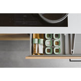 Kitchen drawer organizer with compartments for spices and utensils.